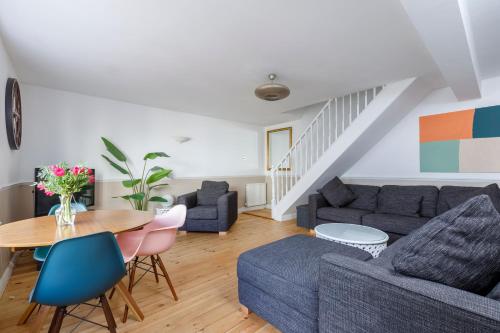 een woonkamer met een bank en een tafel bij Beachfront Getaway 2-Bedroom House with FREE Private Parking & Patio in Brighton & Hove