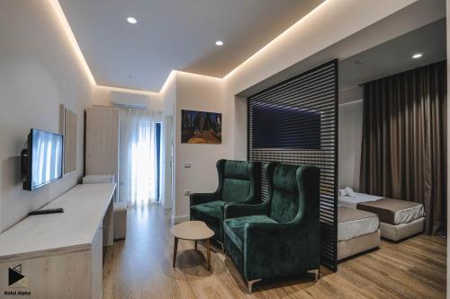 una habitación de hotel con una silla verde y un dormitorio en Hotel Alpha, en Sarandë