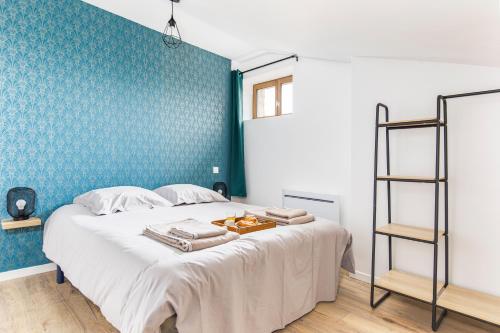 une chambre avec un lit avec un mur bleu dans l'établissement Gambetta402 CahorsCityStay, à Cahors