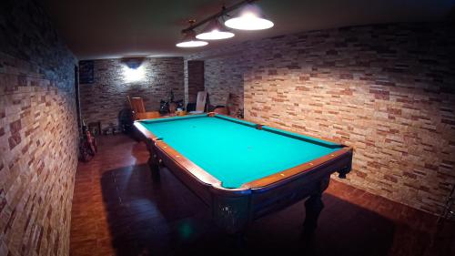 a pool table in a room with a brick wall at Penzion Anička in Klokočov