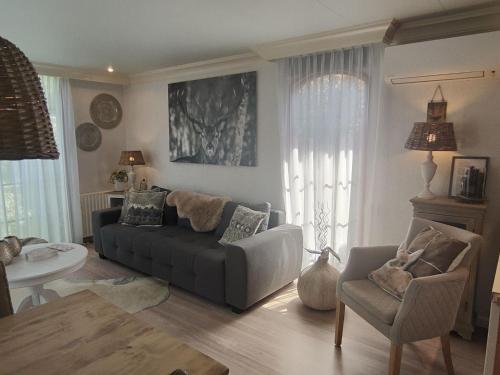 uma sala de estar com um sofá e uma cadeira em Urbane Holiday Home in Garderen with Terrace and Garden em Garderen