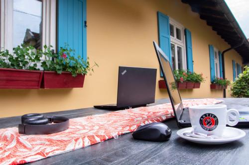 a table with a laptop computer and a coffee cup at Vila Ljubica in Vrnjačka Banja