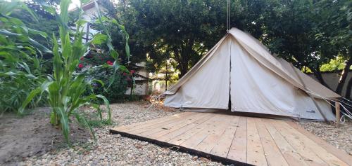 ein Tipi-Zelt auf einer Holzterrasse im Garten in der Unterkunft Magic Garden Emperor Bell Tent in Vama Veche