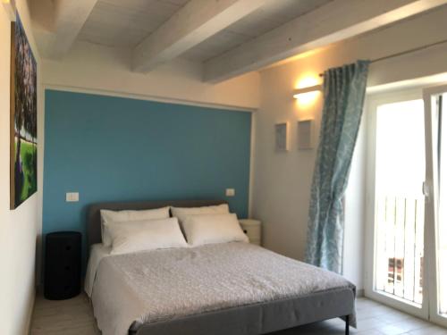 Un Capriccio - Ginepro في Aieta: غرفة نوم بسرير وجدار ازرق