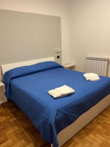 a bedroom with a blue bed with two towels on it at Leone di Nemea - Νεμέος λέων in Reggio Calabria