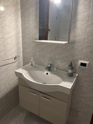 y baño con lavabo blanco y espejo. en Leone di Nemea - Νεμέος λέων, en Reggio Calabria