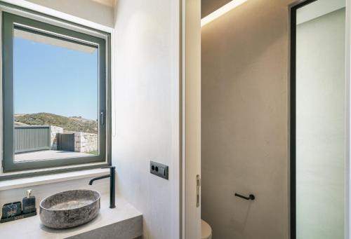 uma casa de banho com um lavatório e uma janela em Villa 7 Seas - With Amazing View em Lefkogeia