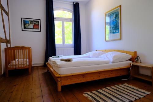 a bedroom with a wooden bed with a window at Gutshaus Thorstorf FeWo Poel in Thorstorf