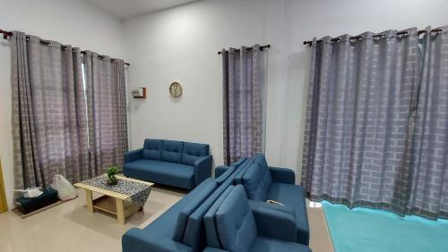 a living room with two blue chairs and a couch at 42 Avenue Homestay Samarahan in Kota Samarahan