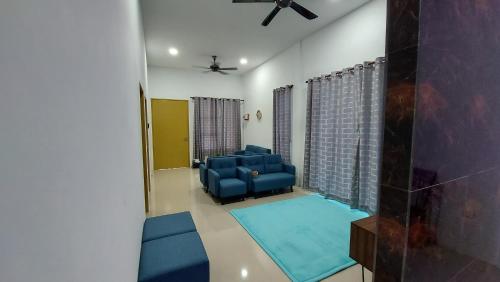 a living room with blue furniture and a ceiling fan at 42 Avenue Homestay Samarahan in Kota Samarahan
