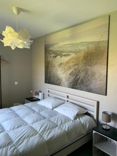 una camera da letto con un letto e un dipinto sul muro di Sur le chemin des phoques a Saint-Valéry-sur-Somme