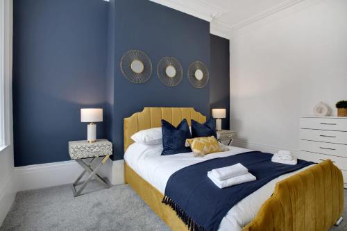 ein Schlafzimmer mit einem großen Bett mit blauen Wänden in der Unterkunft Stunning 4-Bedroom, 2 Bathrooms in Sunderland in Sunderland
