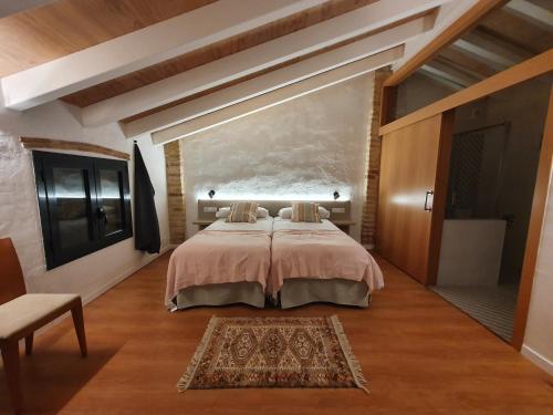 a bedroom with a bed and a large wall at la Creveta in Tivissa