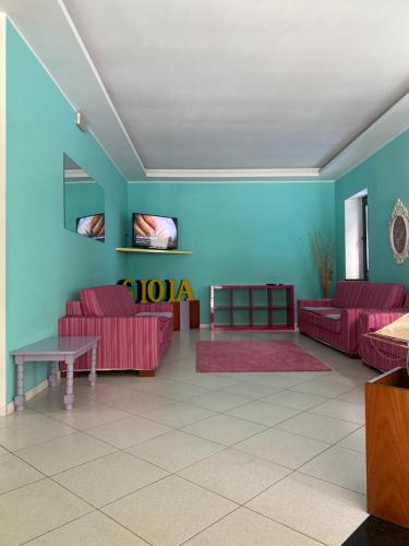 una sala de estar con sofás rojos y una pared azul en Hotel Gioia, en San Benedetto del Tronto