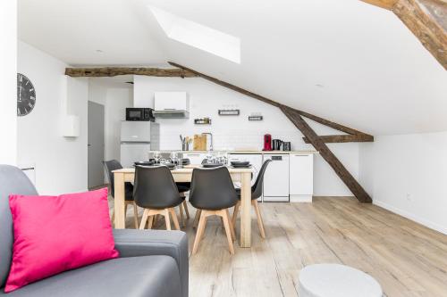 un salon avec un canapé et une table avec des chaises dans l'établissement Gambetta 403 CahorsCityStay, à Cahors