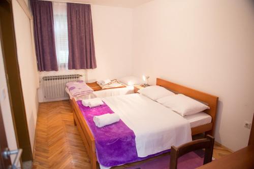 a bedroom with a bed with two towels on it at Pansion Palma in Međugorje