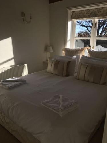 a white bed in a bedroom with a window at Waters edge in Rolvenden