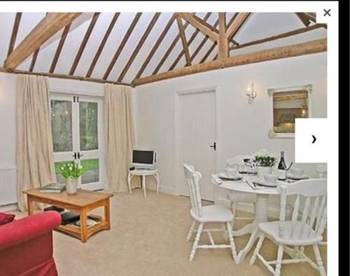 a living room with a white table and chairs at Waters edge in Rolvenden