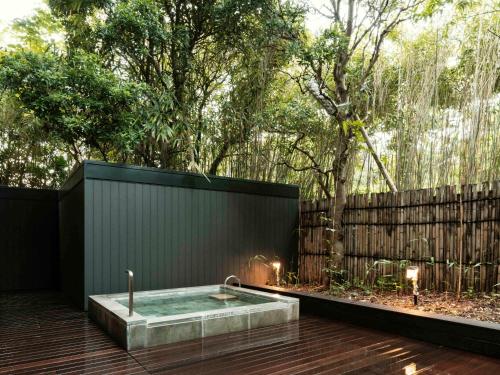 a hot tub in a backyard with a fence at Numazu Club in Numazu