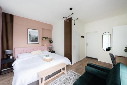 a bedroom with a large white bed and a couch at Penzion Mezi buky in Chřibská