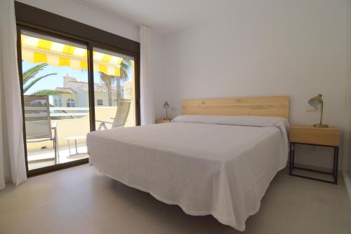 a bedroom with a white bed and a balcony at Las Mimosas in La Cala de Mijas