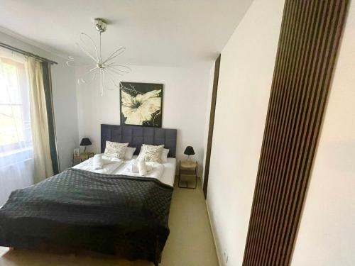 1 dormitorio con cama y lámpara de araña en "Apartament pod Śnieżką" uroczy apartament z kominkiem, en Karpacz