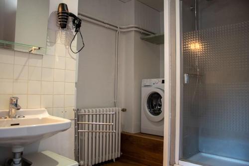 Mende Sweet Home - Vue Cathédrale - Wifi - Centre ville في مندي: حمام مع مغسلة وغسالة ملابس