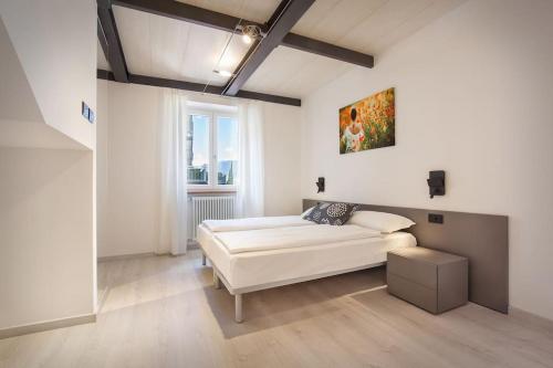 Habitación blanca con cama y ventana en Il Frantoio a Lago en Malcesine