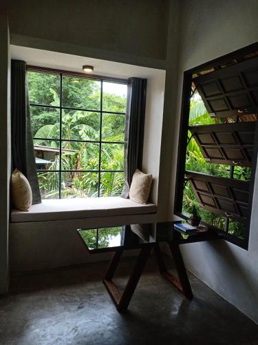 a window seat in a room with two windows at Cheeva at pai ชีวา แอท ปาย in Pai