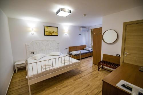 a bedroom with a white bed and a mirror at Casa Ypu in 2 Mai