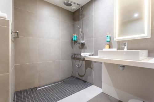 a bathroom with a sink and a shower at Novotel Bourges in Bourges