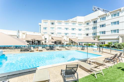 a swimming pool in front of a hotel at Novotel Bourges in Bourges