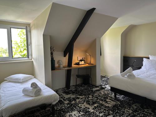 a bedroom with two beds and a desk in it at Logis Hôtel & Restaurant Le Vert Bocage in Franqueville-Saint-Pierre