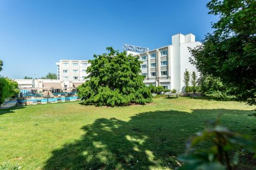 a tree in a park in front of a building at Novotel Bourges in Bourges