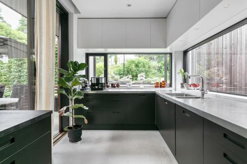 uma cozinha com armários verdes e uma grande janela em Swedish Elegance & Luxury Home em Estocolmo