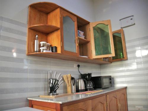 una cucina con armadi in legno e piano di lavoro di Success Apartments-Gold a Mwanza