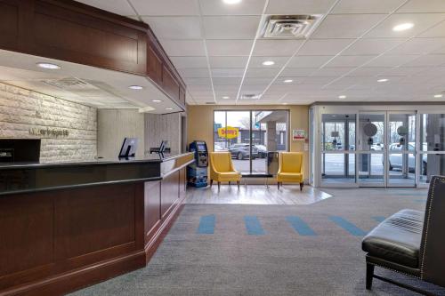 an office lobby with yellow chairs and a counter at Days Inn by Wyndham Niagara Falls Near The Falls in Niagara Falls