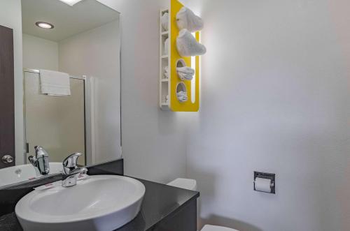 Un baño con lavabo, inodoro y espejo. en Motel 6 Riverton WY, en Riverton