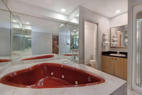 a large red tub in a bathroom with a toilet at Days Inn by Wyndham Niagara Falls Near The Falls in Niagara Falls