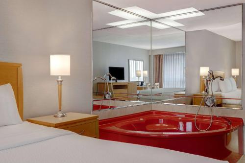 a hotel room with a bath tub with a mirror at Days Inn by Wyndham Niagara Falls Near The Falls in Niagara Falls