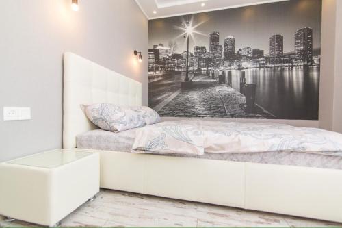 Un dormitorio con una cama con un mural de una ciudad. en apartmen, en Sumy