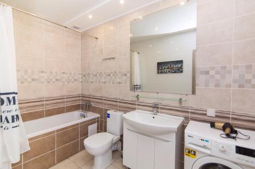 Un baño con inodoro, lavabo y espejo. en apartmen, en Sumy