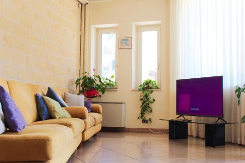 a living room with a couch and a tv at Hotel Mille Pini in Ginosa Marina