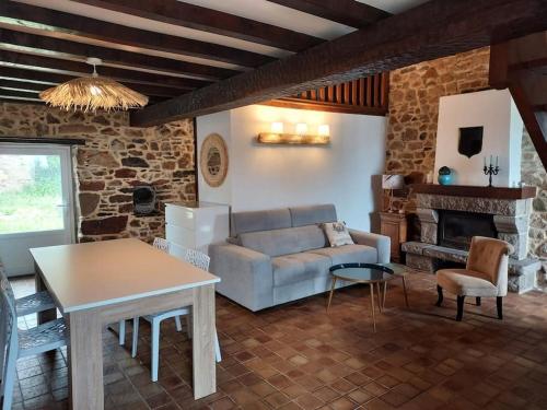 ein Wohnzimmer mit einem Sofa und einem Tisch in der Unterkunft SCIOTOT-BORD DE MER - LA GRANGE in Les Pieux
