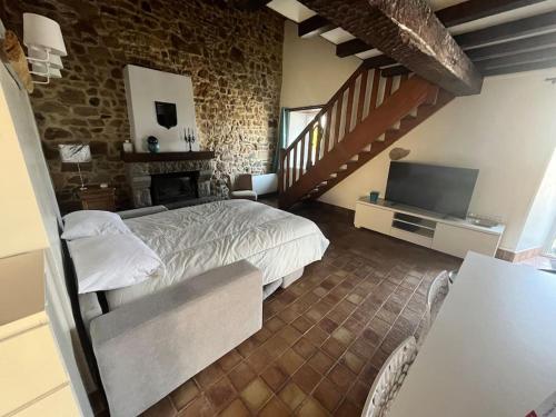 ein Schlafzimmer mit einem Bett und einer Steinmauer in der Unterkunft SCIOTOT-BORD DE MER - LA GRANGE in Les Pieux