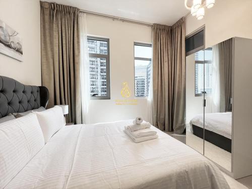 a bedroom with a large white bed and two windows at Marina Wharf II Dubai Marina - AL Maraseem in Dubai