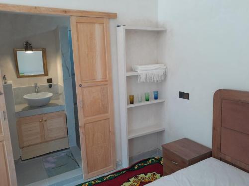 a bathroom with a sink and a toilet and a mirror at Chez Youba in Rbat