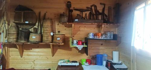 a room with a wooden wall with shelves and utensils at Velemun brvnara in Plav