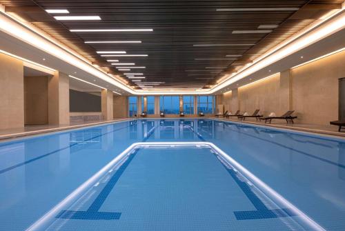 - une grande piscine dans un grand bâtiment dans l'établissement Wyndham Shaoxing Keqiao, à Shaoxing