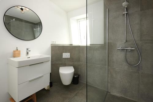 a bathroom with a shower and a toilet and a sink at Seaside in Laboe